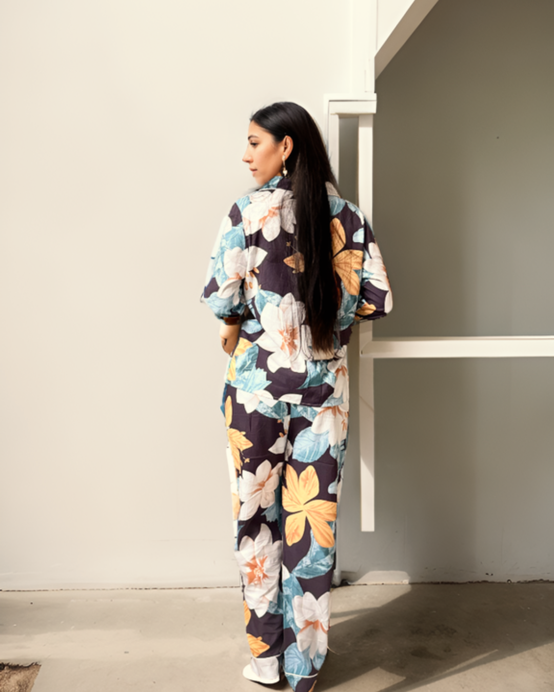 Model wearing Prana Poshak's floral print pajama set in a natural outdoor setting, highlighting its breathable and eco-friendly fabric