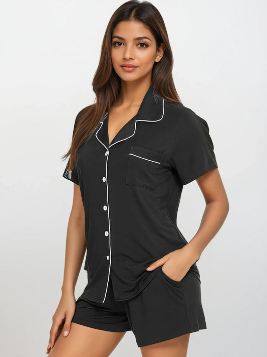 Model in black bamboo short sleeve pajama set by Prana Poshak – classic button-down top with white piping and shorts